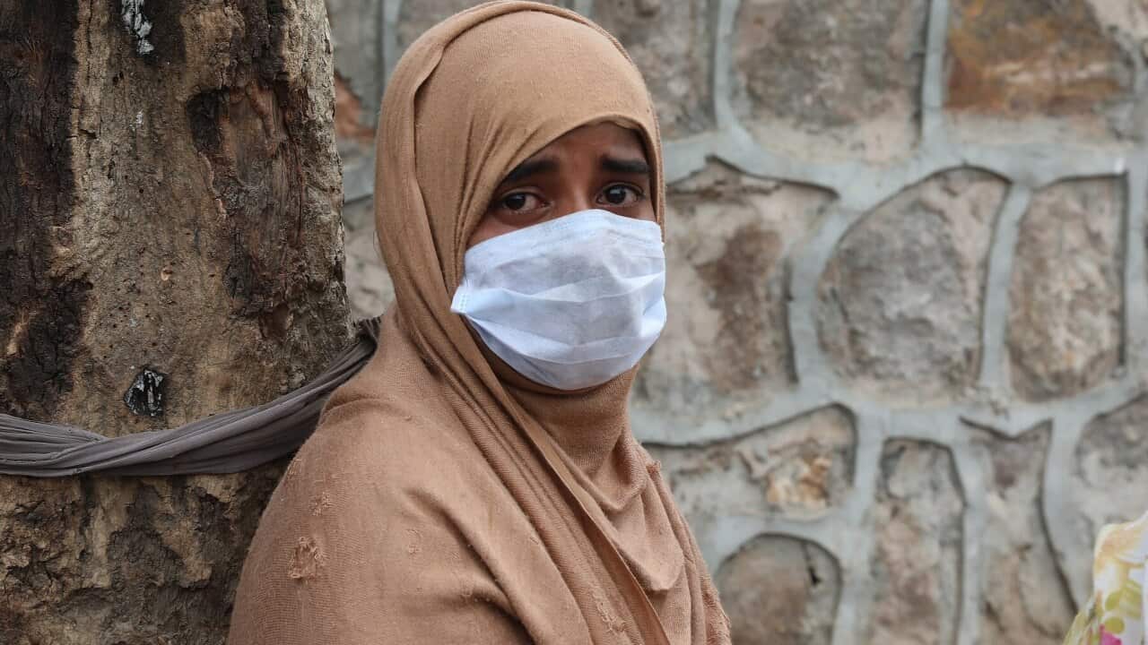 A Rohingya woman reacts after a fire damaged her shanti at a refugee camp in New Delhi, India