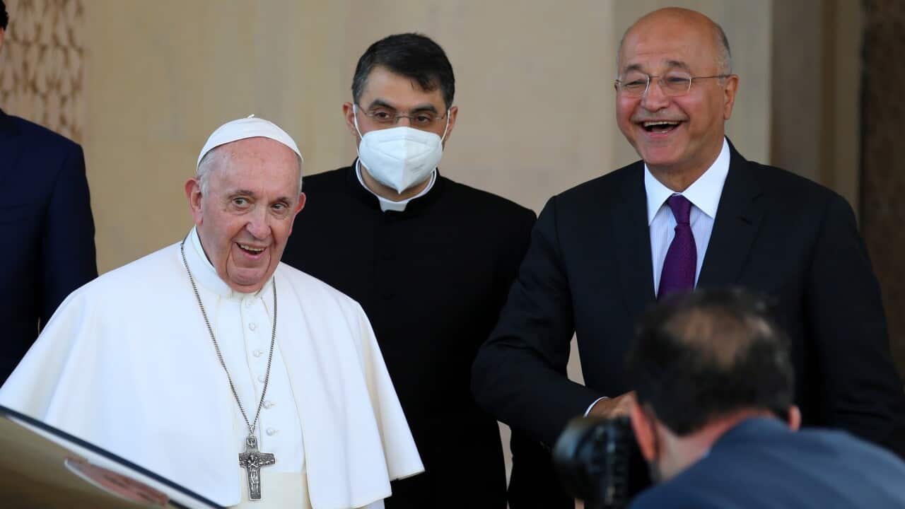Pope Francis is given a farewell by Iraqi President Barham Salih as he leaves the Presidential Palace.