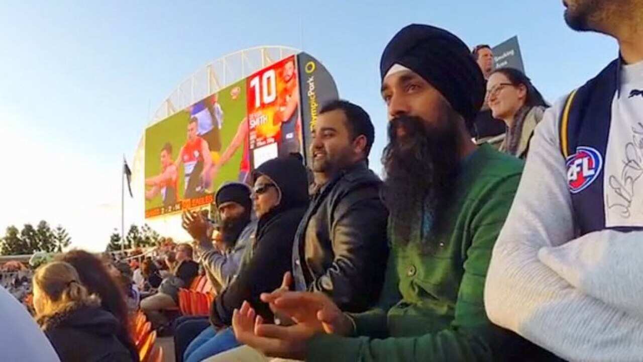 Footy fans attend  an AFL match