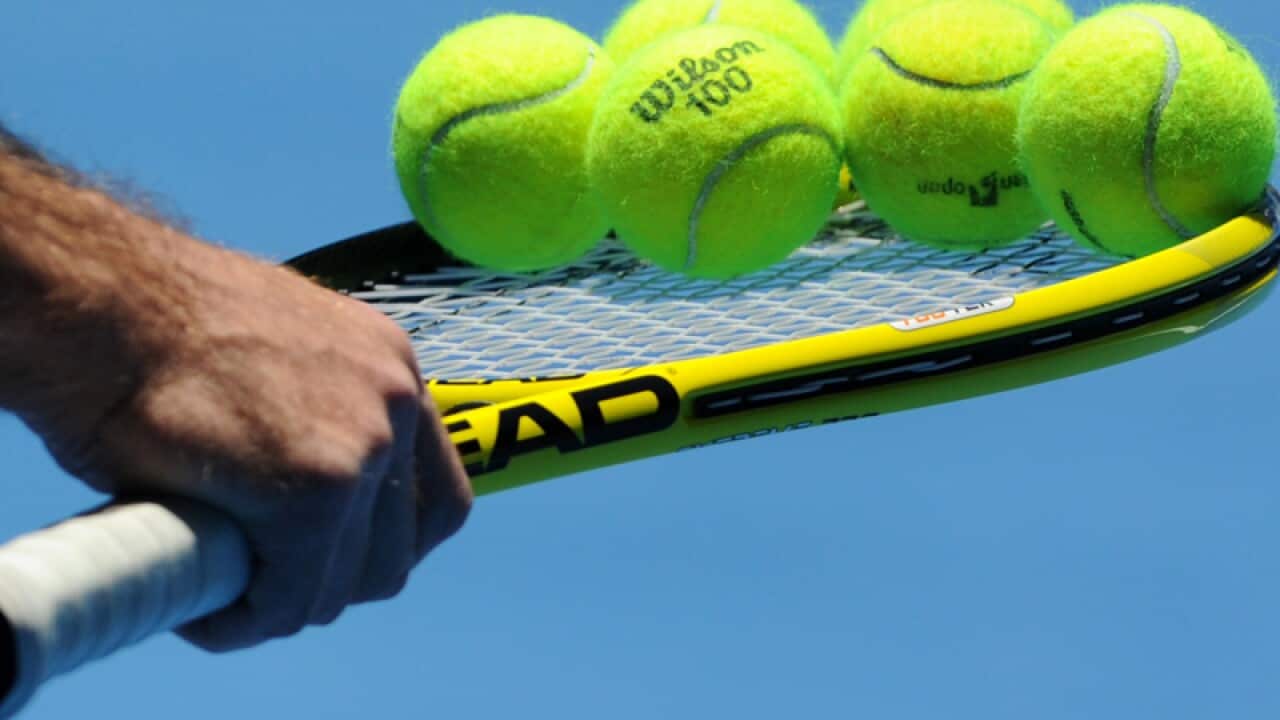 A tennis racquet and balls