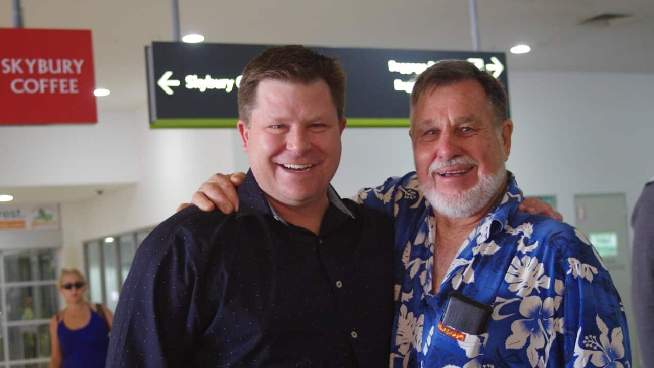 Andrew and his father Gary smiling for a photograph. 