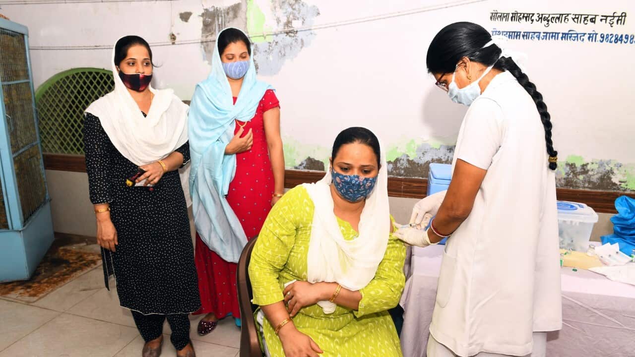 Health worker administers a dose of COVID-19 vaccine to a muslim woman during a special vaccination drive at a mosue in Beawar, India (AAP)