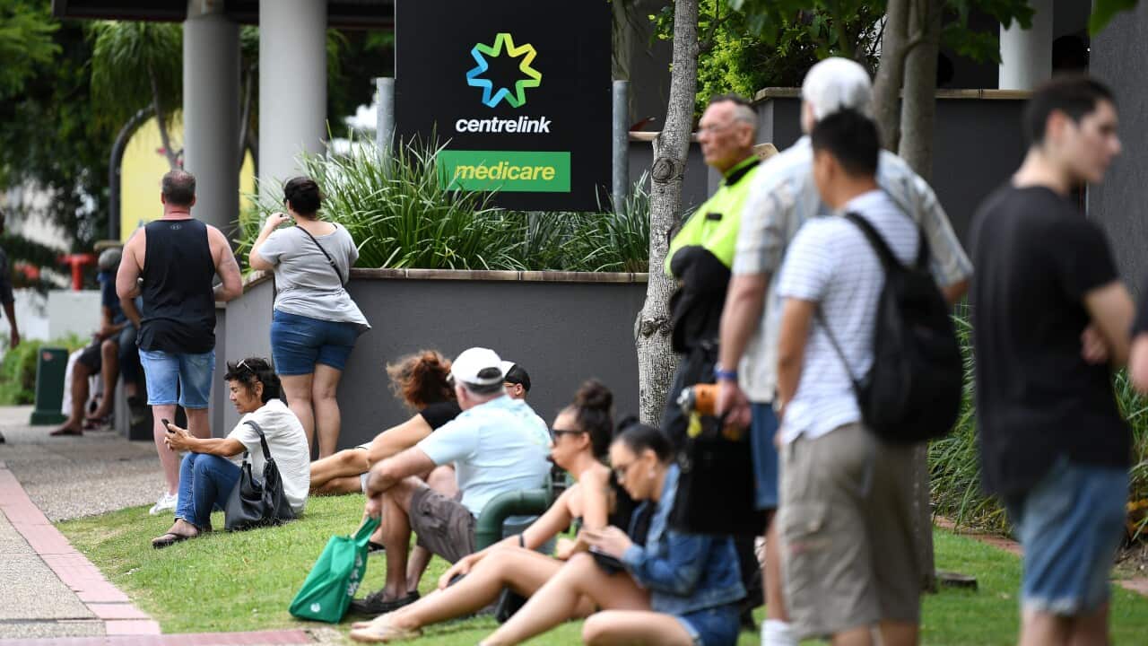 People are seen in long queues outside the Centrelink pandemic
