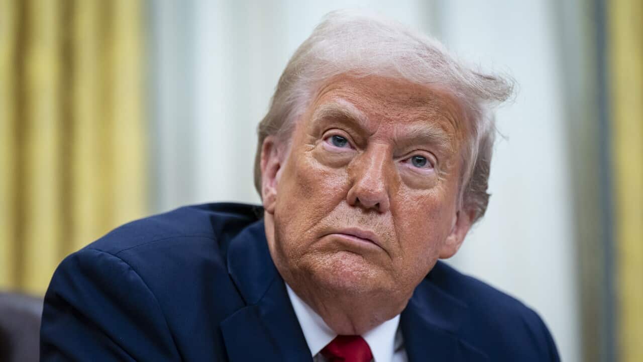 President Donald Trump wearing a suit in the Oval Office