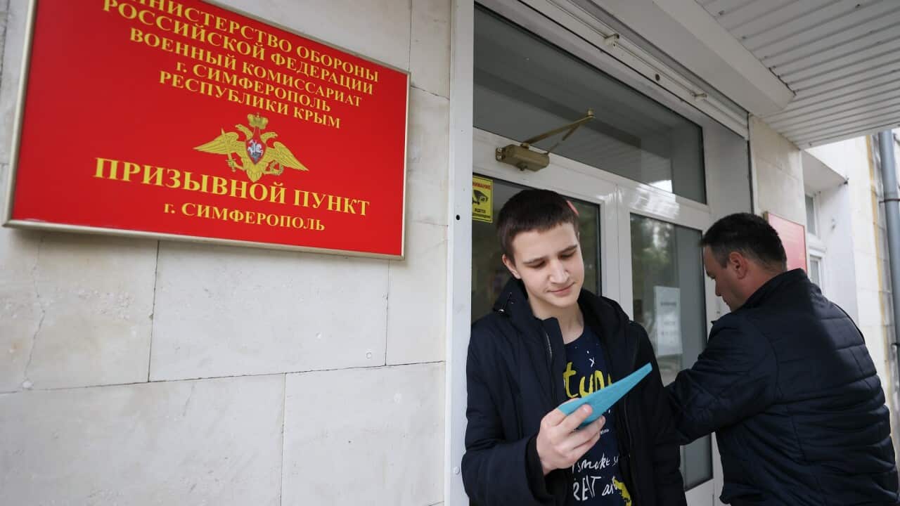 A Russian conscript looks at documents outside of a local enlistment office during a recruitment drive for the spring 2023 military campaign.