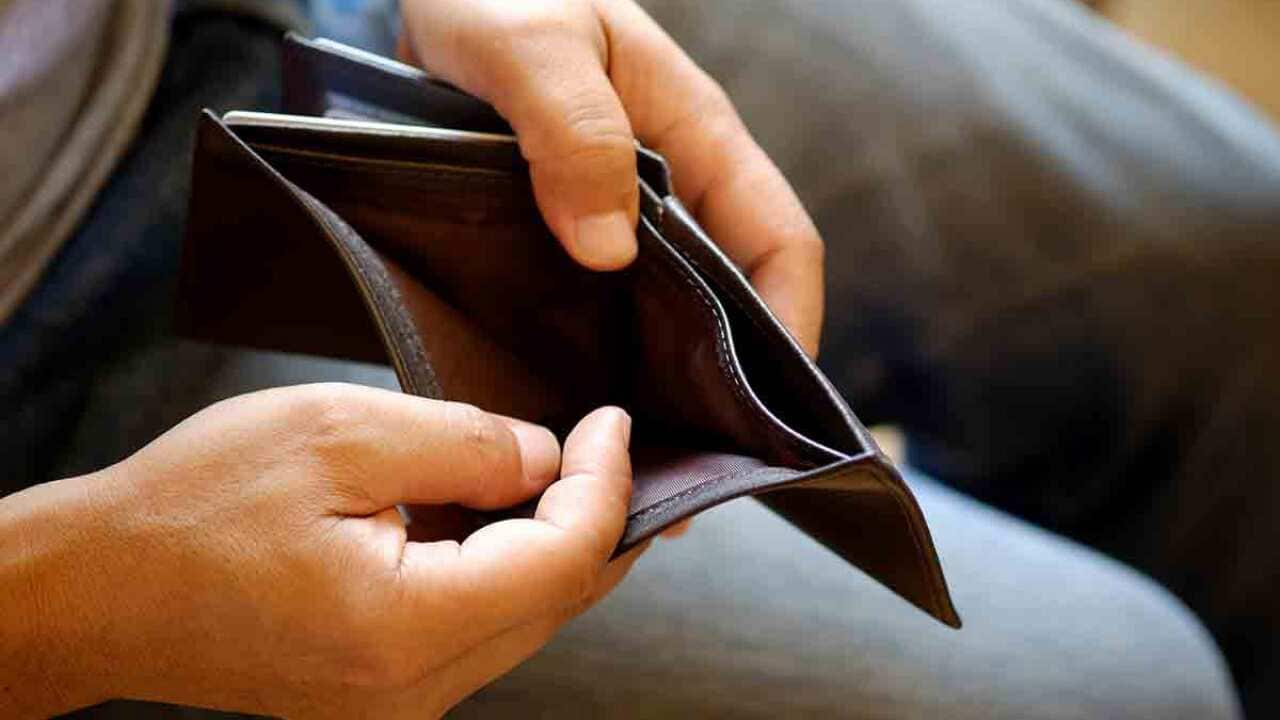 Man holding open empty wallet