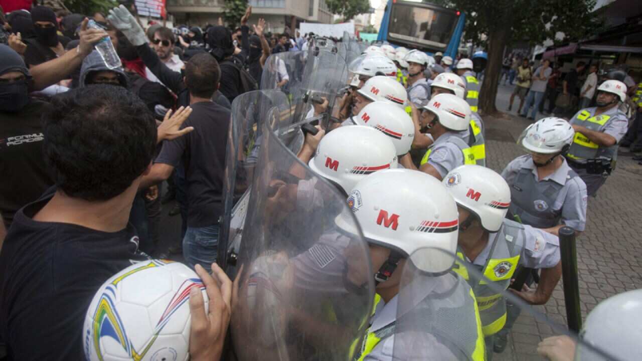 Military policemen block demonstrators during a World Cup protest