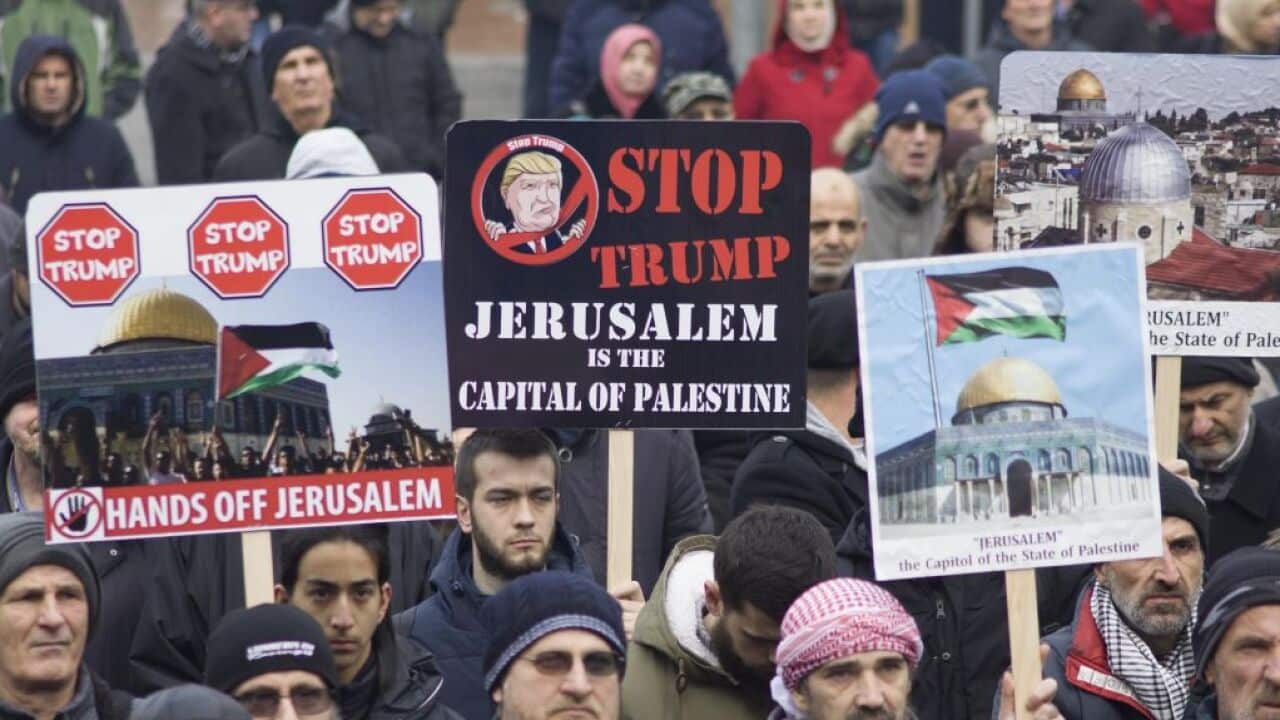 People in Bosnia and Herzegovina hold banners during a protest against Donald Trump's announcement.