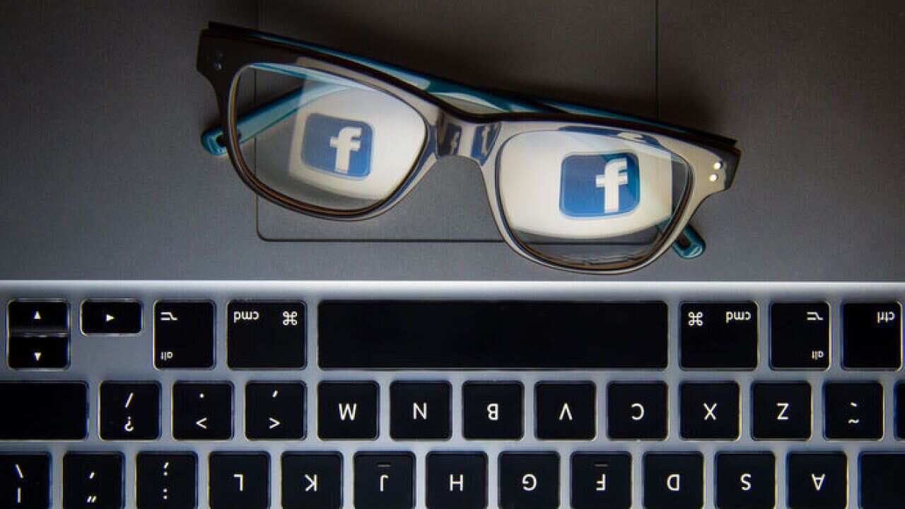 Facebook's logo reflected in a pair of glasses