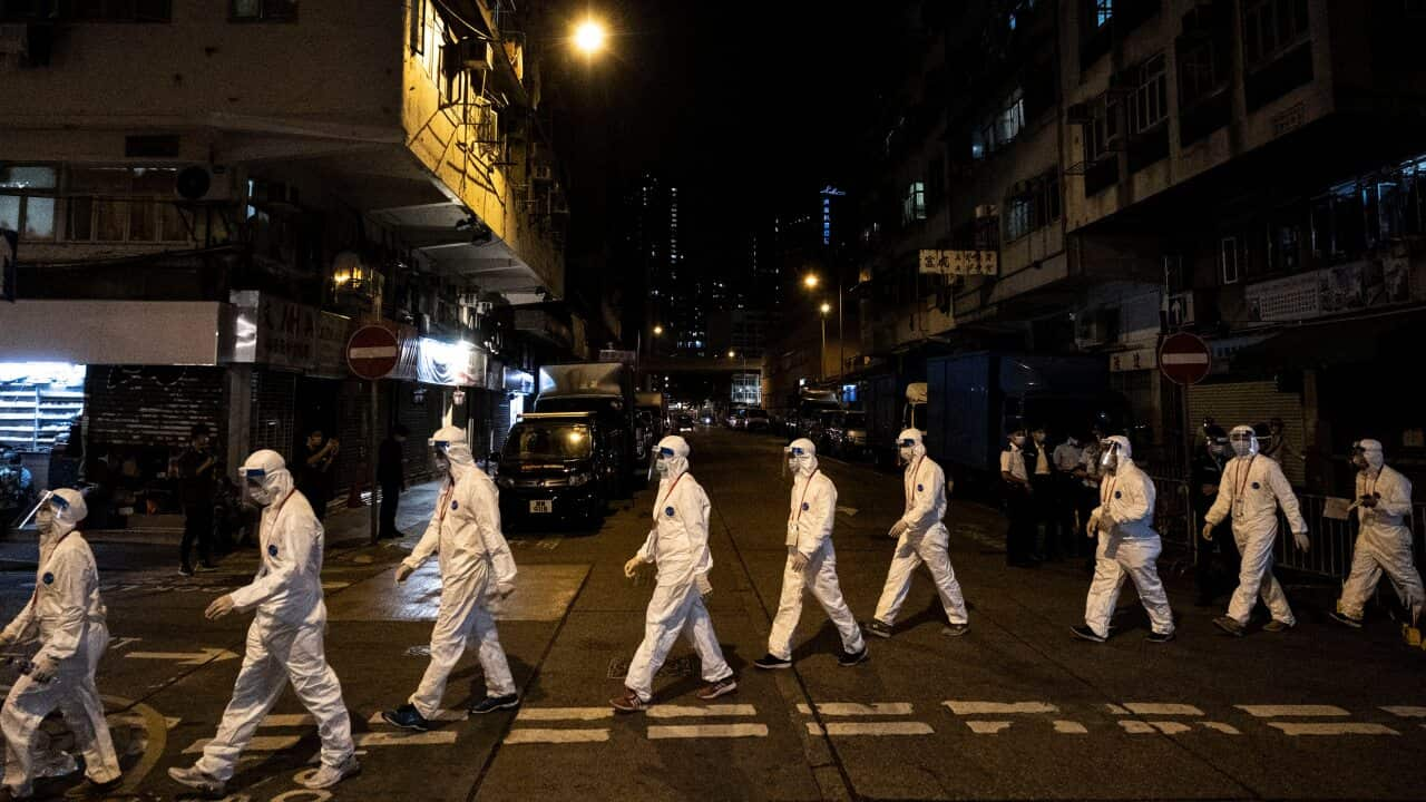 Government workers wearing personal protective equipment work in the Jordan area of Hong Kong, which is under heavy restrictions due to the  pandemic.