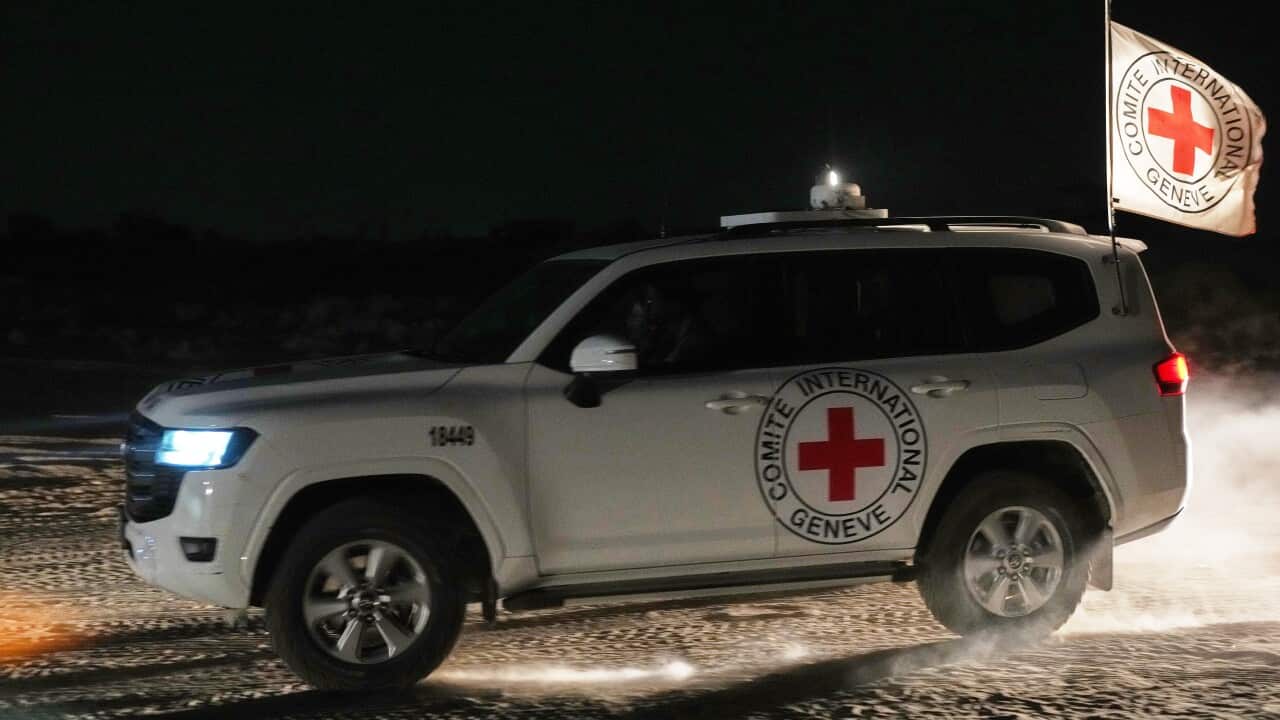 A white four wheel drive at night with a red cross logo on its side