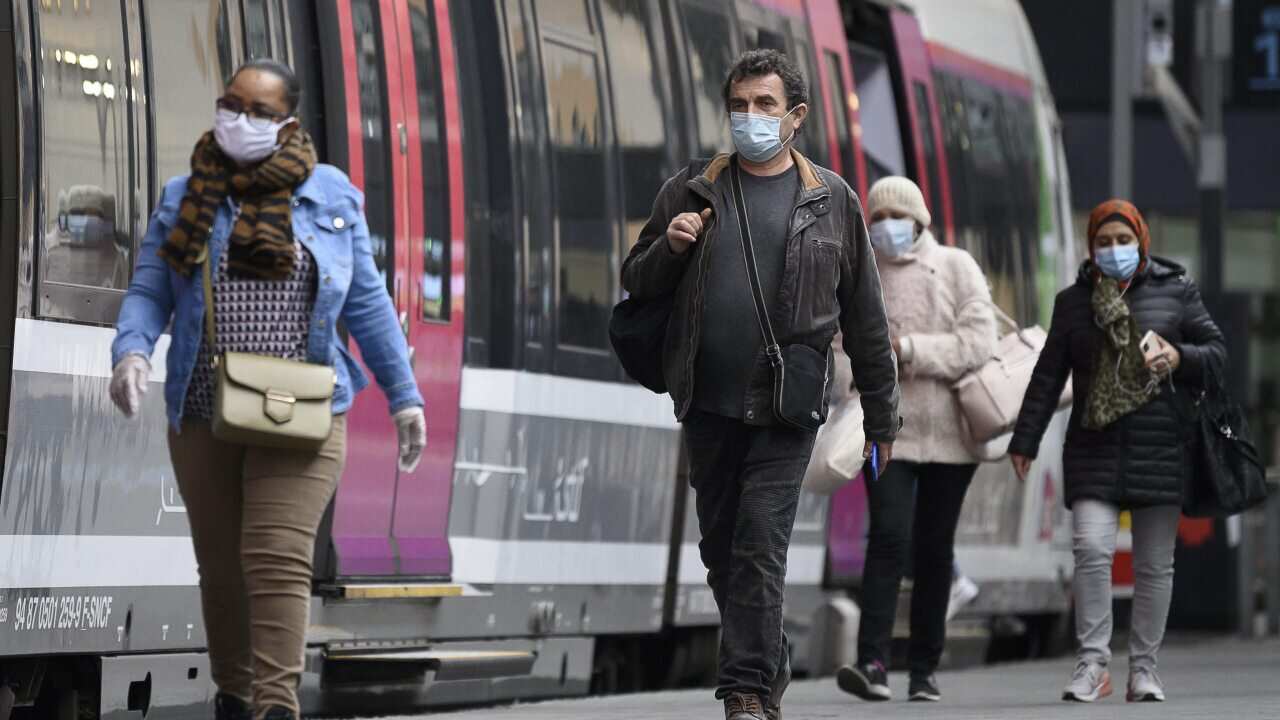 People wearing a protective mask and alternative mask arrive at the train station Gare Saint Lazare in Paris, France, 28 April 2020.