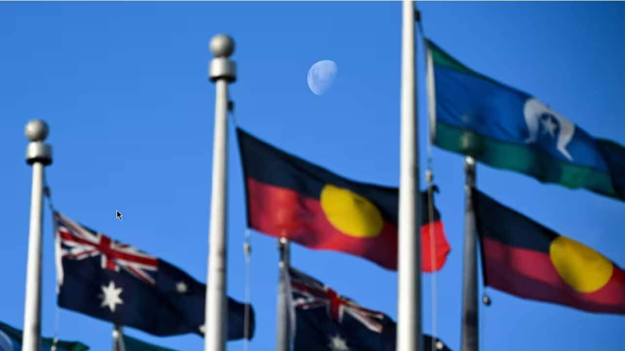 The moon is seen behind the Australian flag, the Indigenous flag and the flag of the Torres Strait Islands flying outside Parliament House to mark Reconciliation week in Canberra, Tuesday, May 30, 2023. (AAP Image/Lukas Coch) NO ARCHIVING Source: AAP / LUKAS COCH/AAPIMAGE
