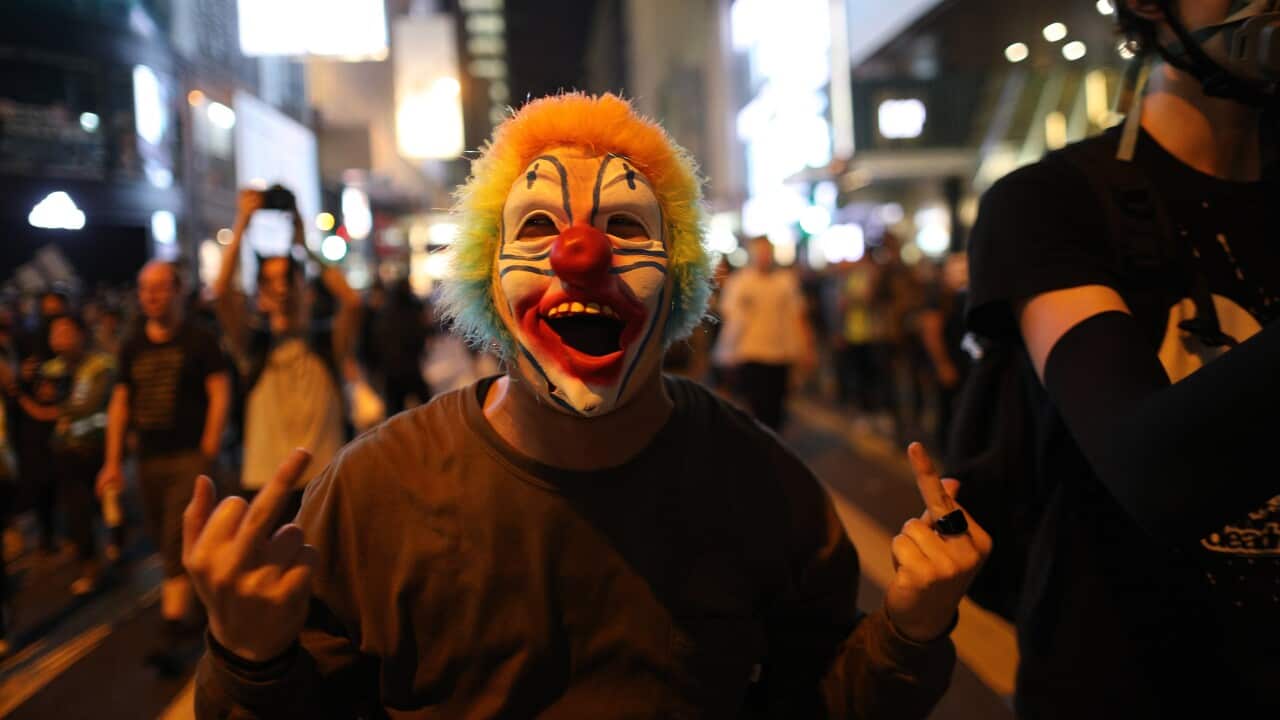 A protester in clown costume gestures at police during a Halloween rally in Lan Kwai Fong, a bar district in Central in Hong Kong.