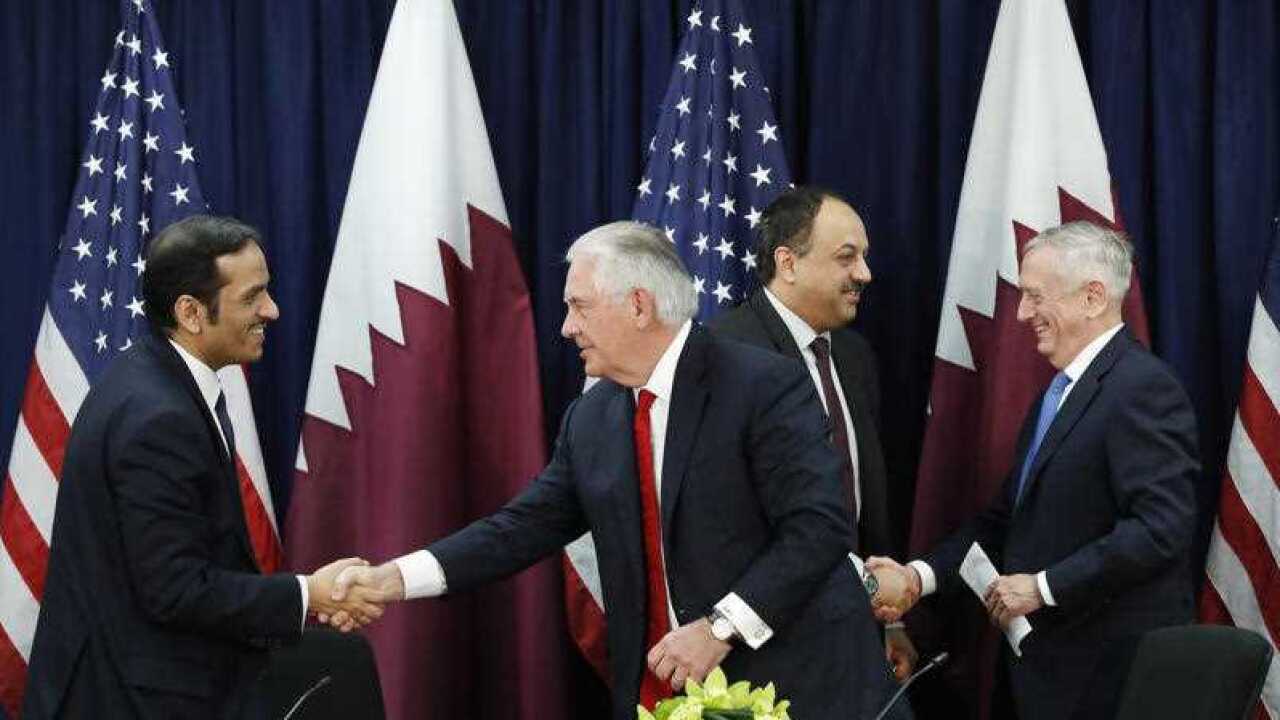 Qatar's Foreign Minister Sheikh Mohammed bin Abdulrahman Al Thani, left, shakes hands with Secretary of State Rex Tillerson, as Qatar's Defense Minister Khalid bin Mohammed al-Attiyah, shakes hands with Defense Secretary James Mattis.