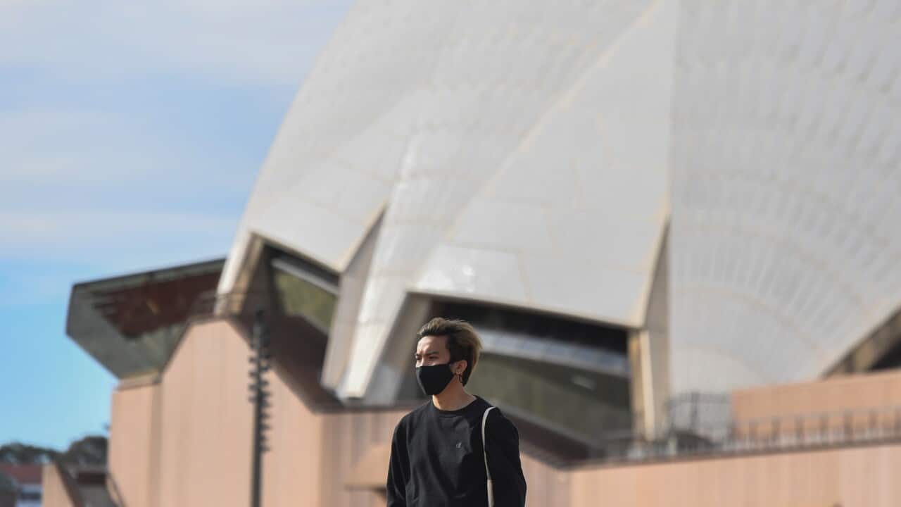 A pedestrian is seen wearing a face mask in the Sydney Opera House in Sydney, Tuesday, August 4, 2020