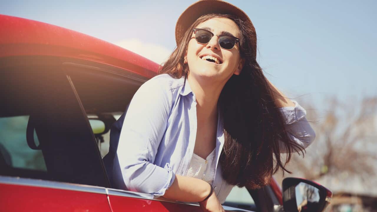 Woman with her hand out of the car window