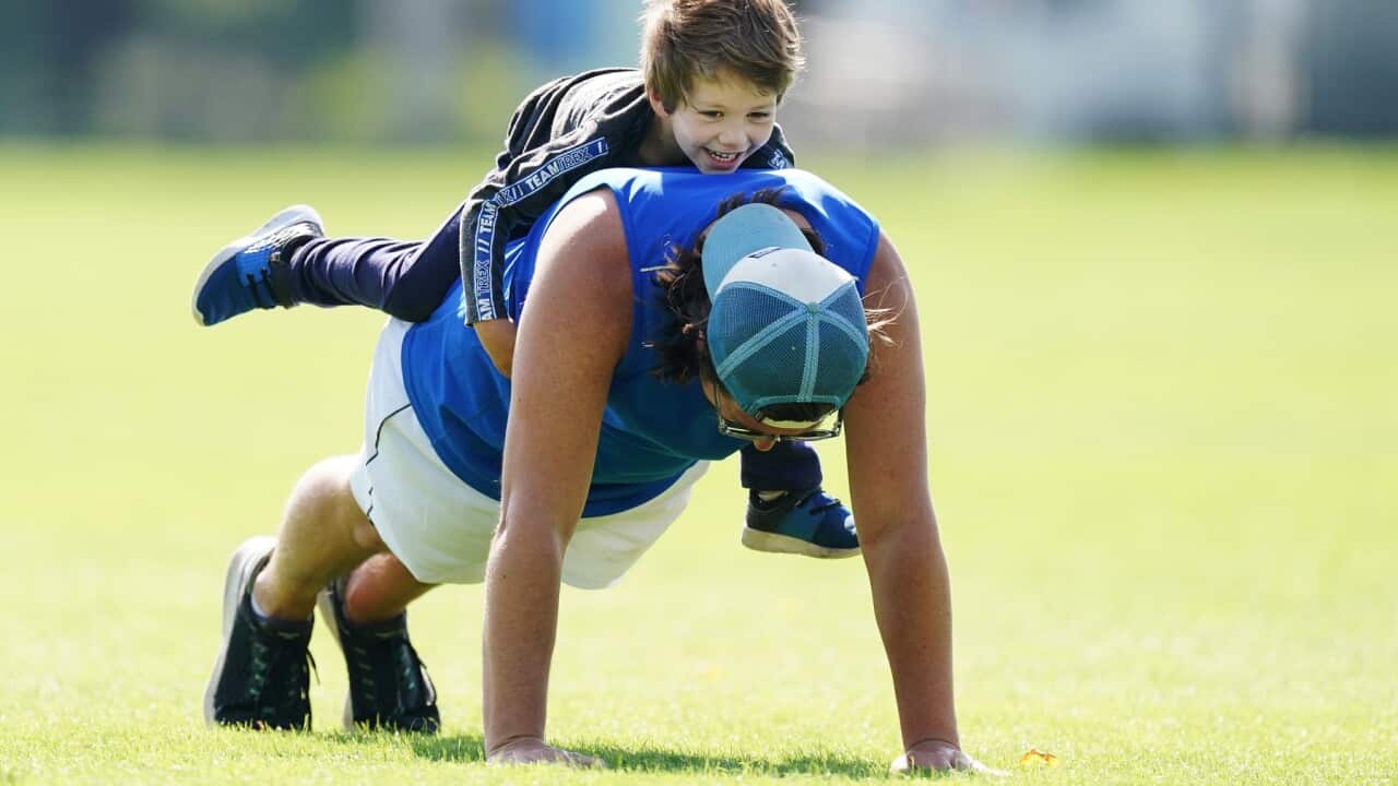 A father trains with his son in Melbourne, Friday, April 3, 2020. Victoria's first weekend since harsher social distancing laws were implemented will start with a ban on all but the most basic outdoor activities. (AAP Image/Michael Dodge) NO ARCHIVING