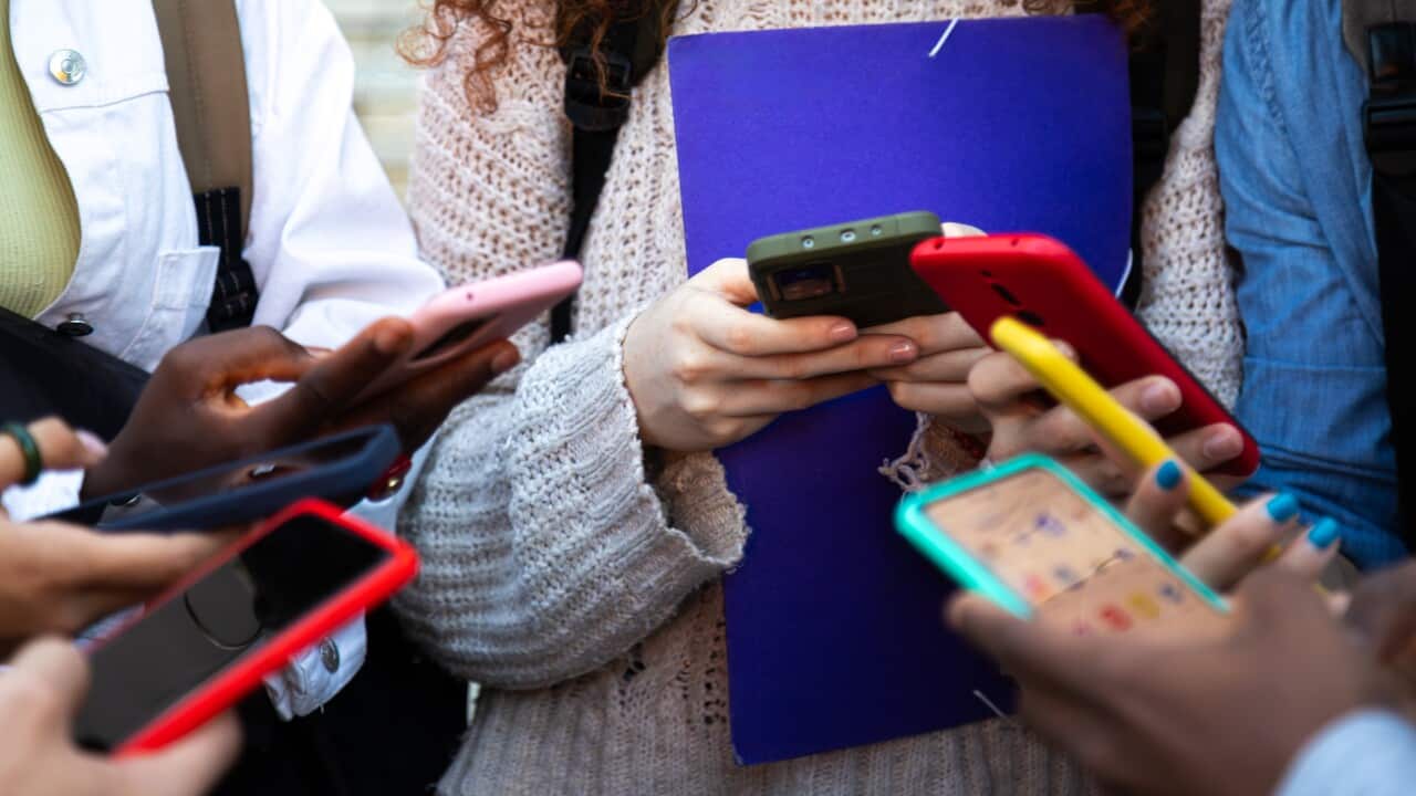 Close up of a group of people holding mobile phones.