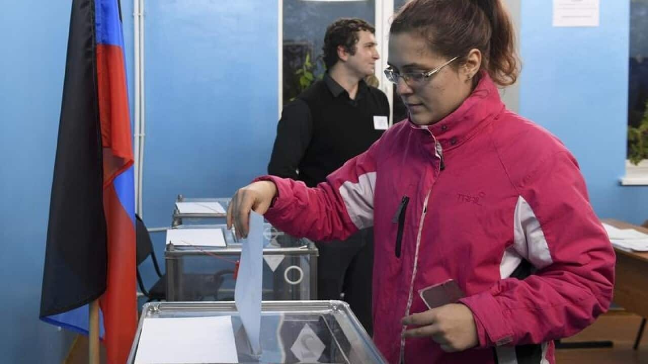 A woman casts her ballot at a polling station in Donetsk, Ukraine