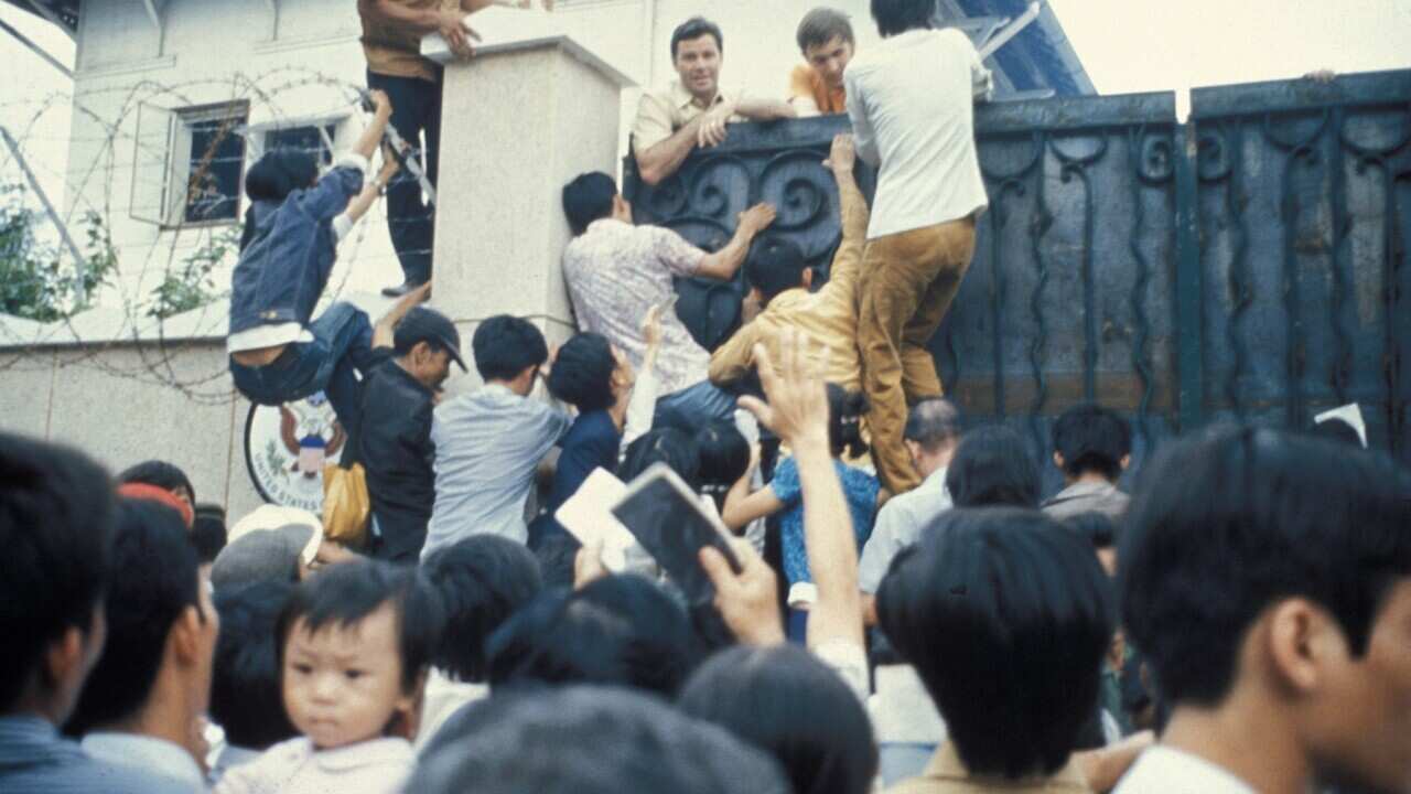 Desperate South Vietnamese citizens try to scale the walls of the American Embassy in 1975