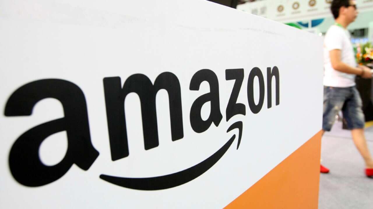 A visitor walks past the stand of Amazon in Shanghai, China