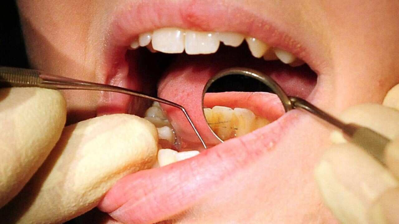 A dentist works on a patient