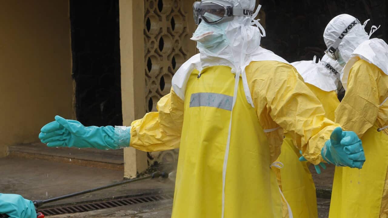 Liberian health care workers are sprayed with disinfectant