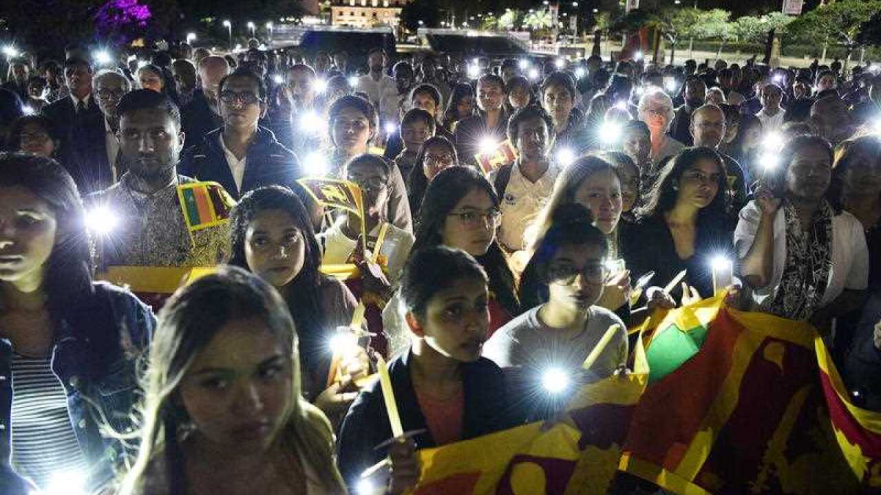 Members of the public join in an interfaith candlelight vigil.