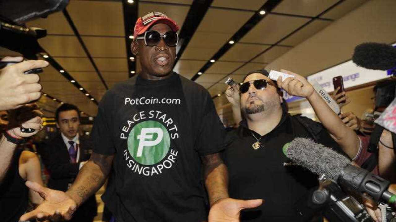 Former NBA basketball player Dennis Rodman, and Chris Volo, right, arrive at Singapore's Changi Airport on Tuesday, June 12, 2018.