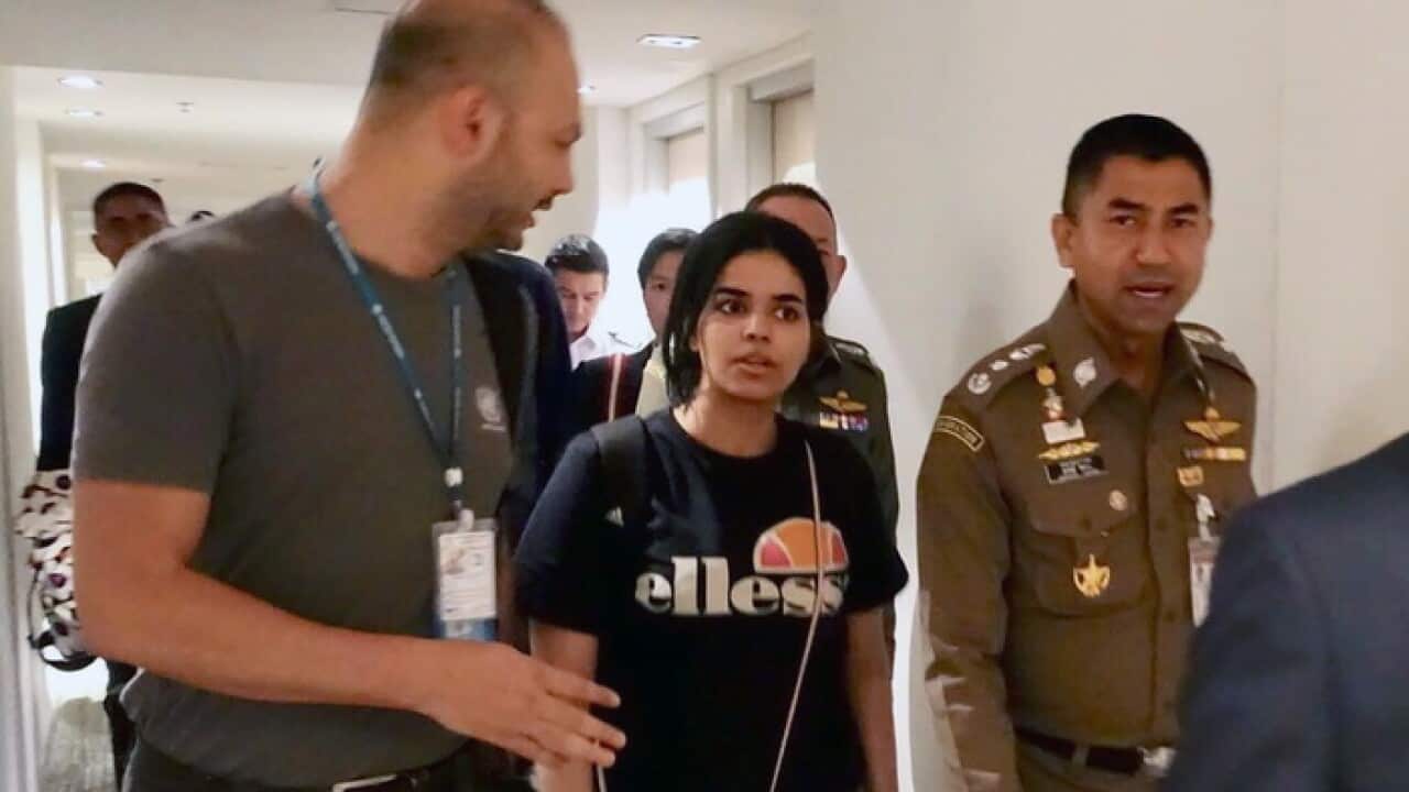 Rahaf Mohammed al-Qunun (C) chats with Thai Immigration Police Chief Surachet Hakparn (R) and unidentified UNHCR officer (L) at a transit hotel in Bangkok