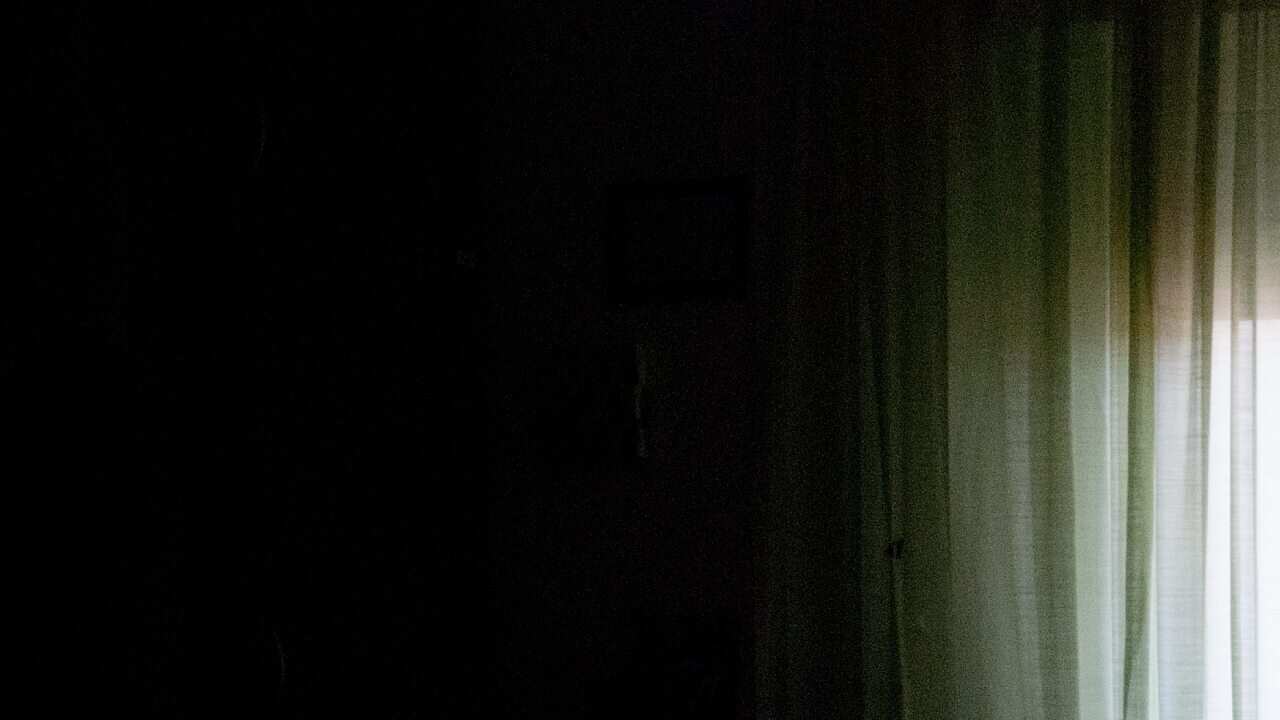 Senior Woman Alone in Dark Room