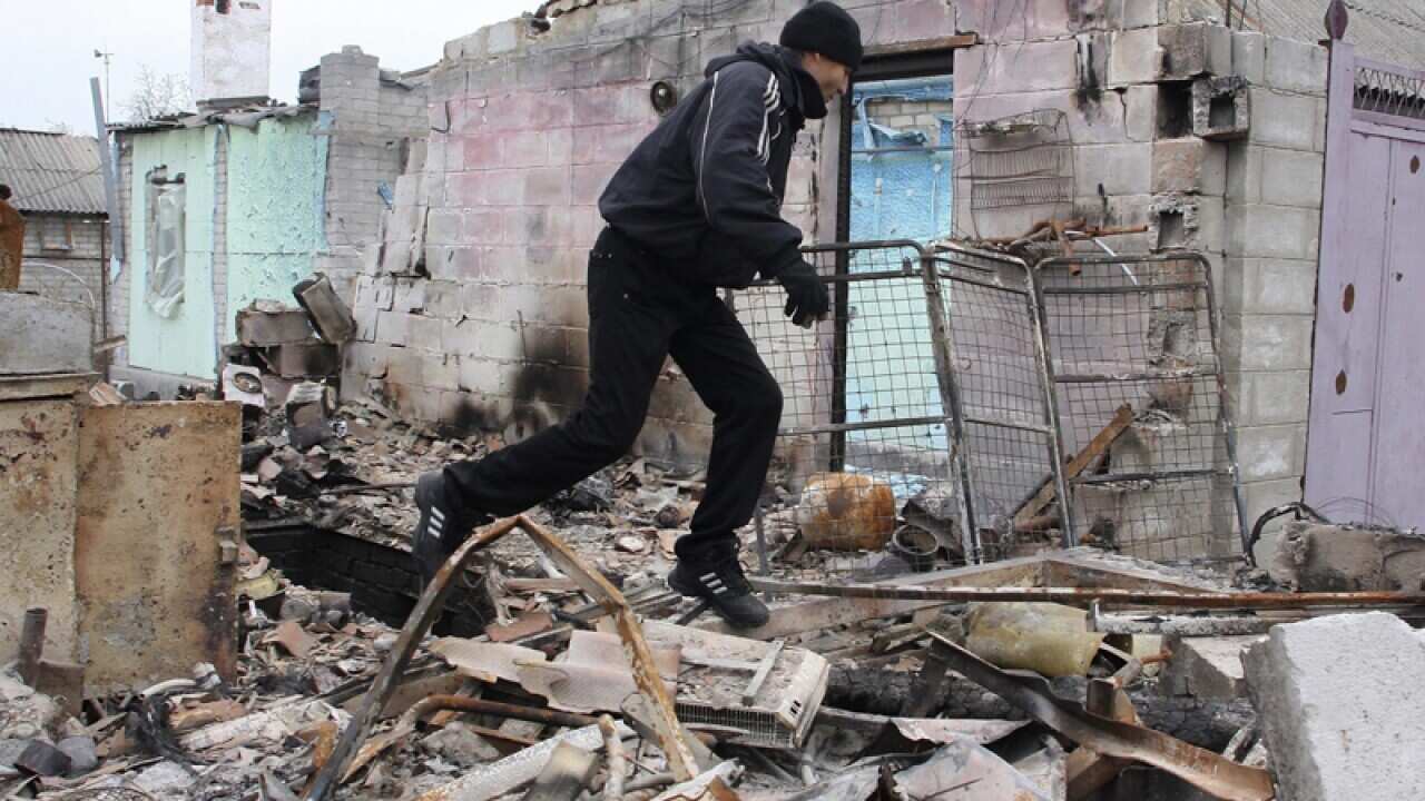 A man investigates debris of buildings in Donetsk