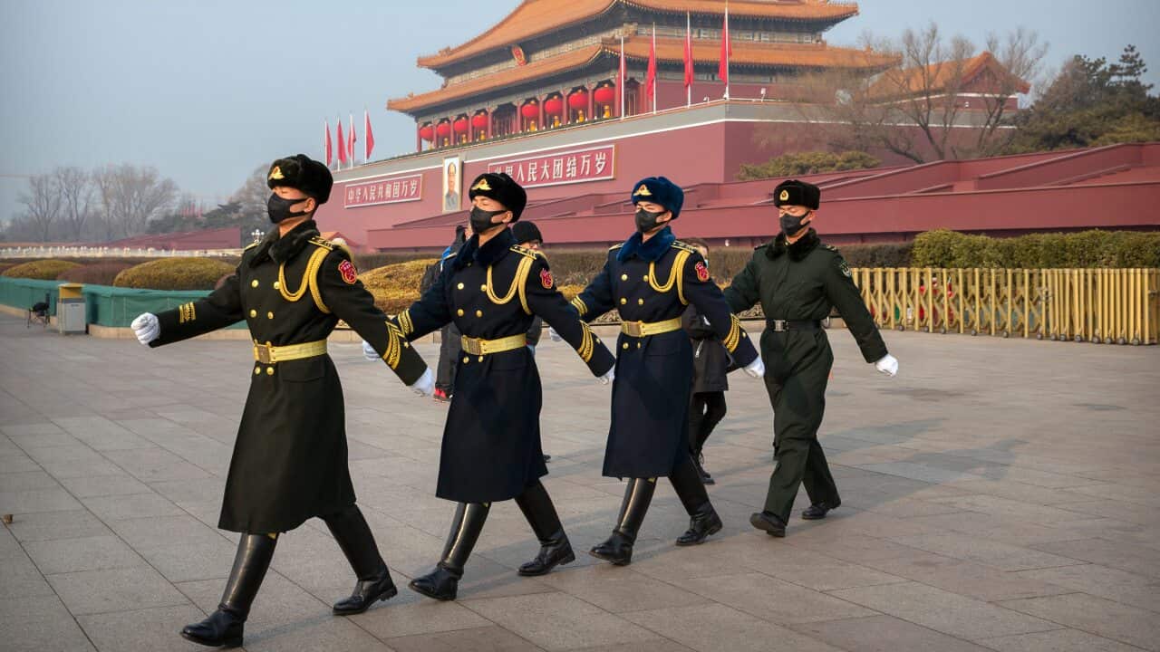 Security officials wear face masks as they march in formation near Tiananmen Gate adjacent to Tiananmen Square in Beijing, Monday, Jan. 27, 2020. China on Monday expanded sweeping efforts to contain a viral disease by postponing the end of this week's Lun