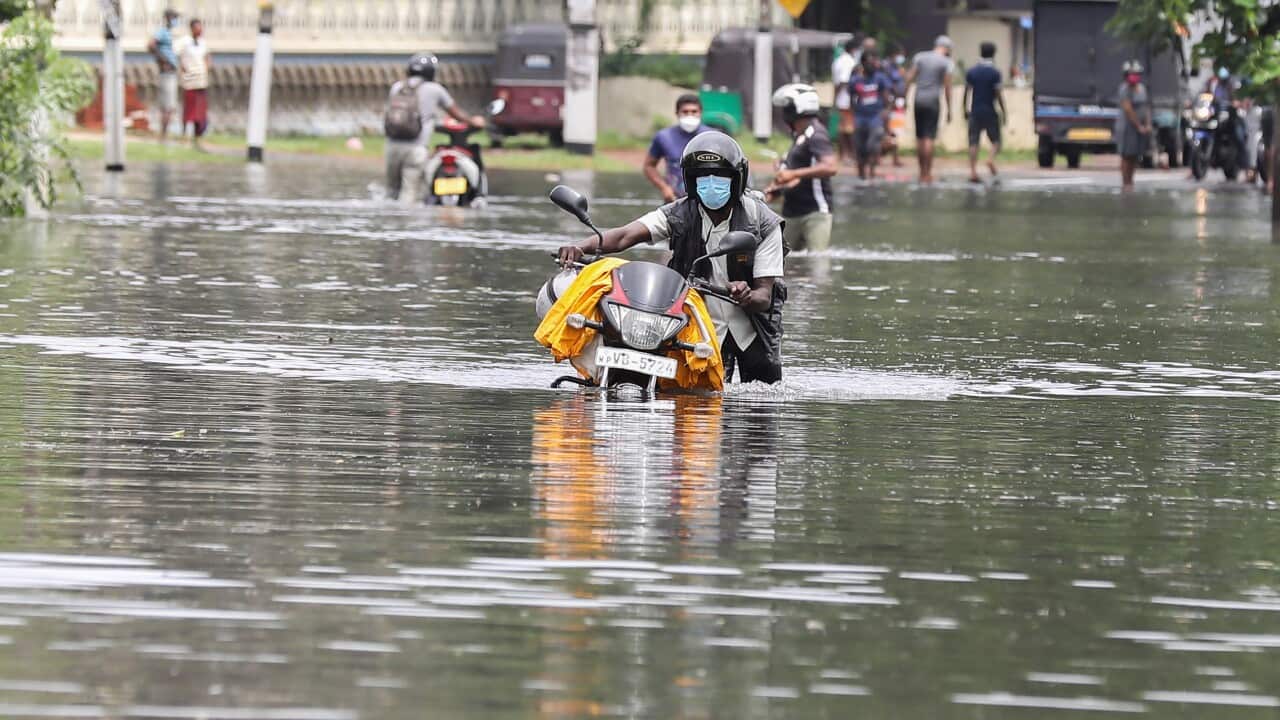 A Sri Lankan man push a motor bicycle through a flooded road after heavy rainfall in Kaduwela suburb of Colombo, Sri Lanka, 05 June 2021.