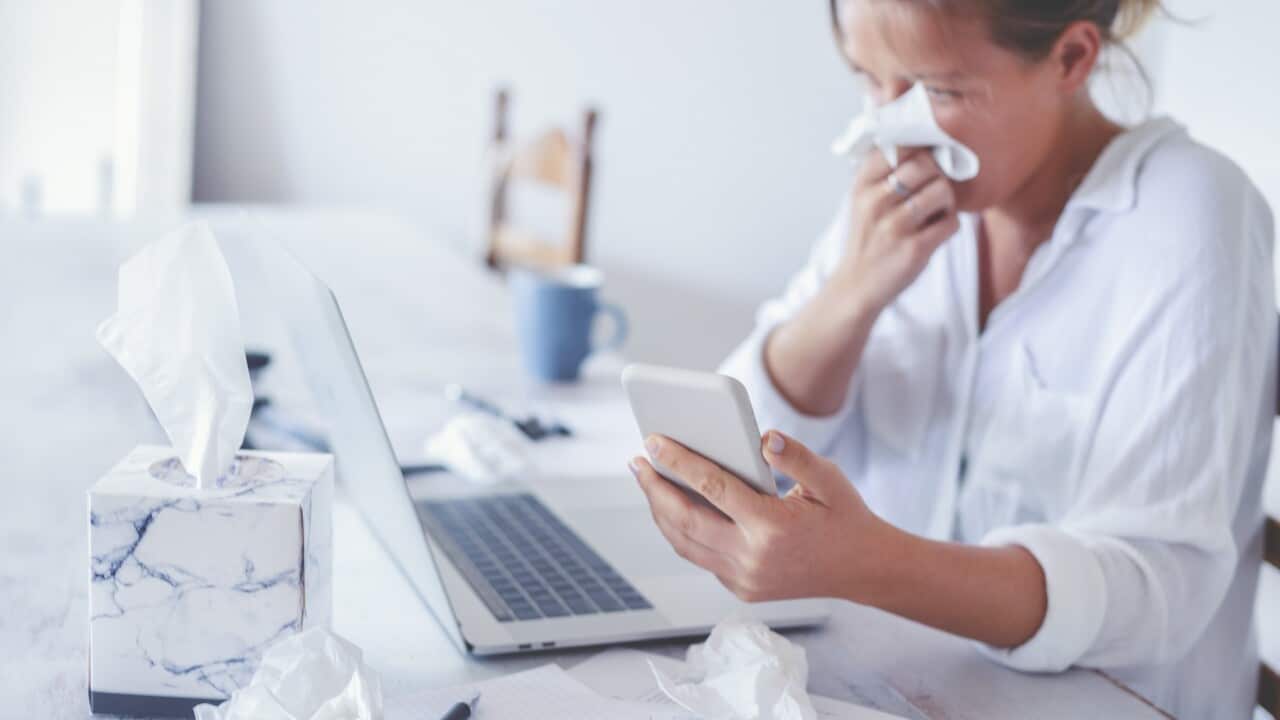 Woman with a cold or flu or allergy working at home