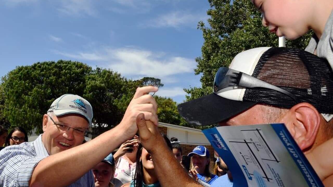 Prime Minister Scott Morrison with constituents at a polling booth.