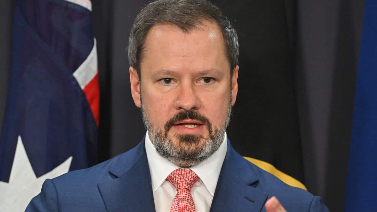 A man wearing a suit and tie speaks.