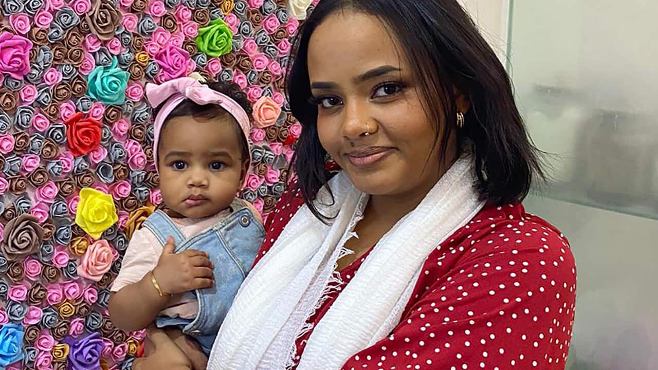 A woman holding her baby daughter.