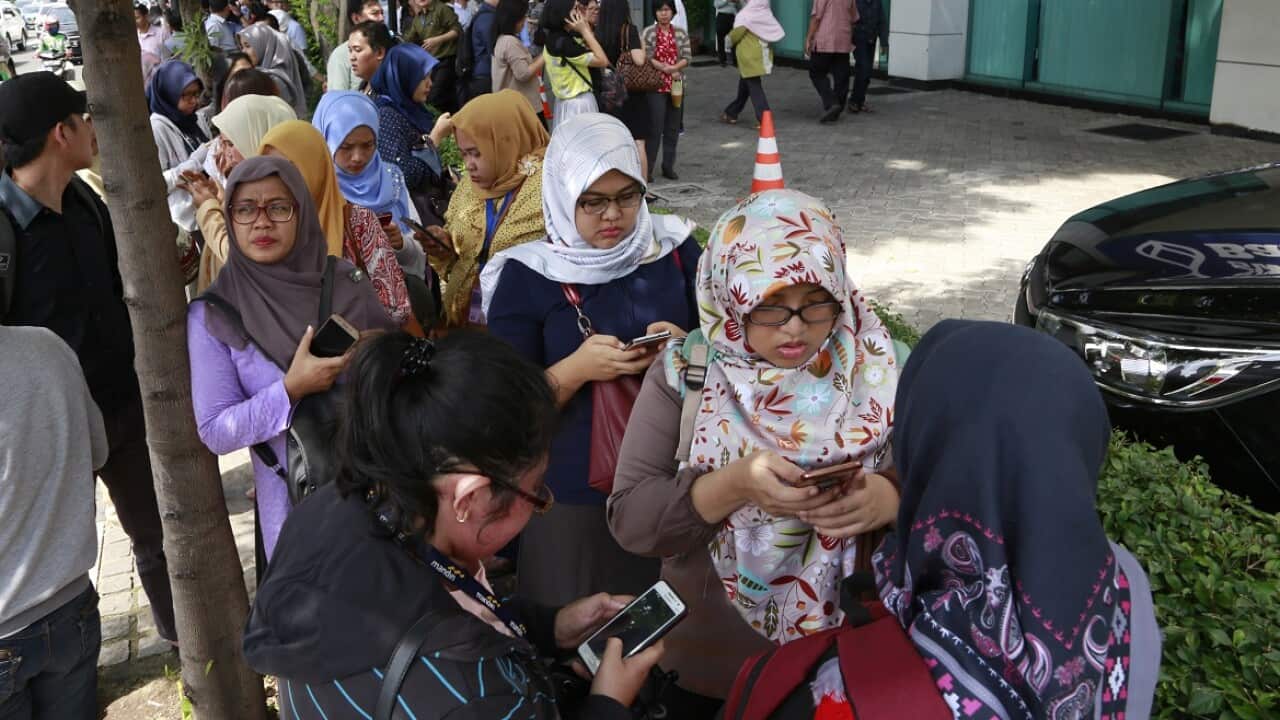 People gather as they evacuate after a strong earthquake in Jakarta, Indonesia.