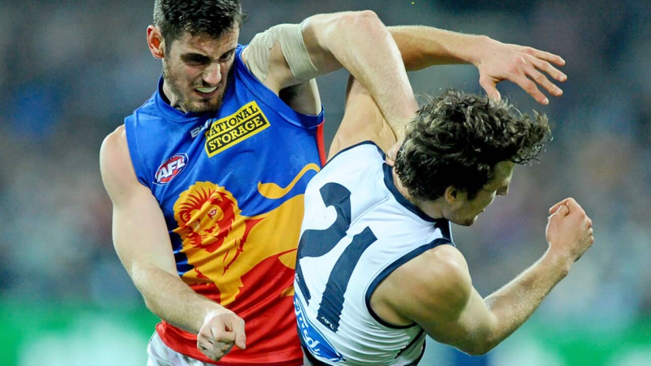 Brisbane's Darcy Gardiner (L) strikes Geelong's Jordan Murdoch