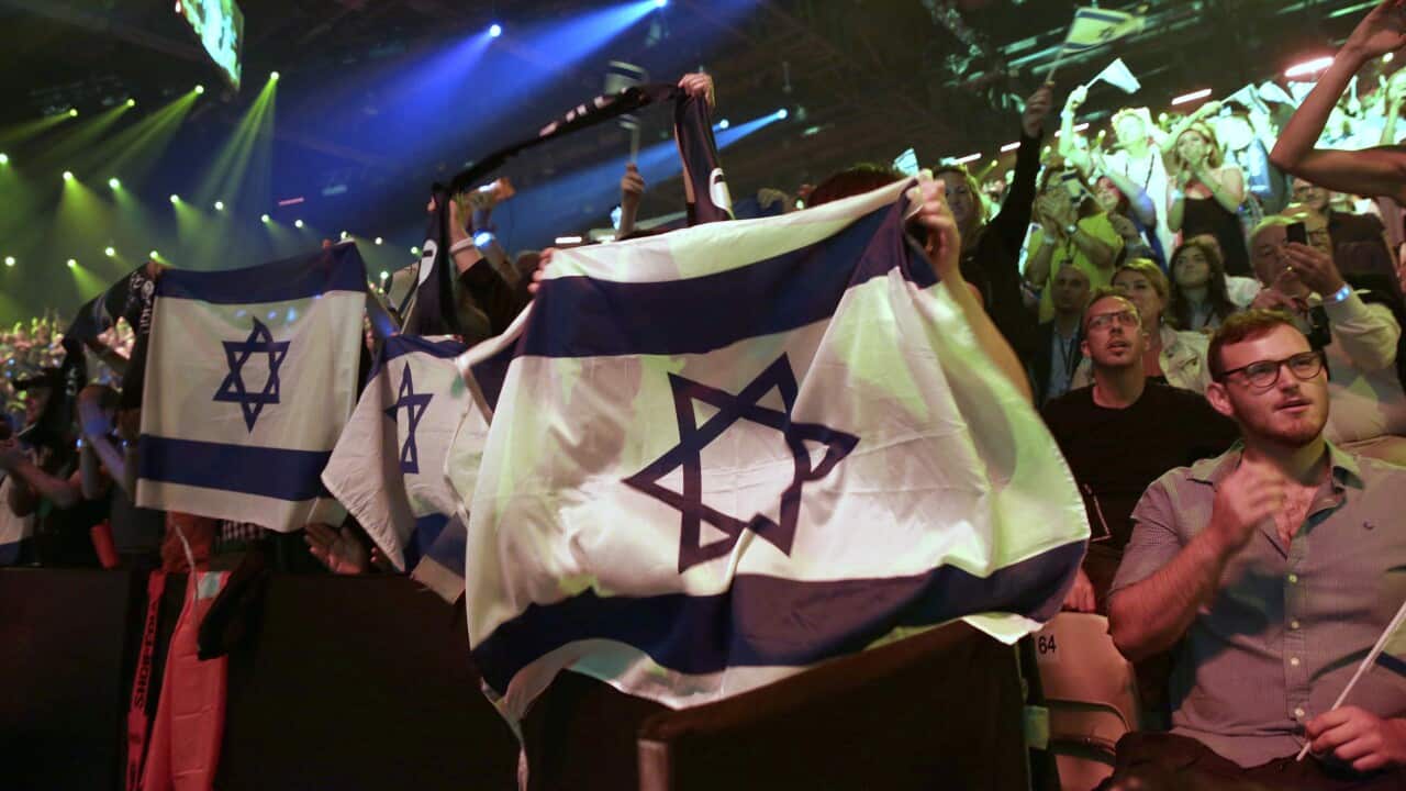 Spectators hold up the Israeli flag while watching the 2019 Eurovision Song Contest grand final in Tel Aviv, Israel.
