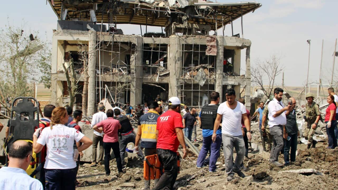 Turkish authorities stand outside a damaged police station