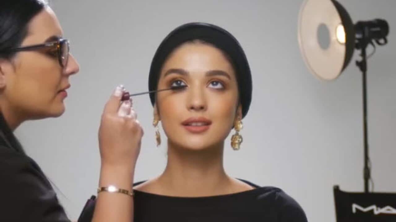 A MAC makeup artist demonstrates a look on a model