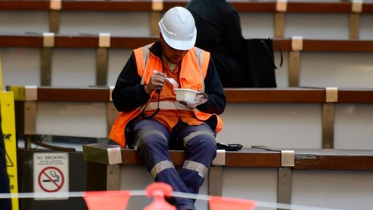A construction worker eating a meal.