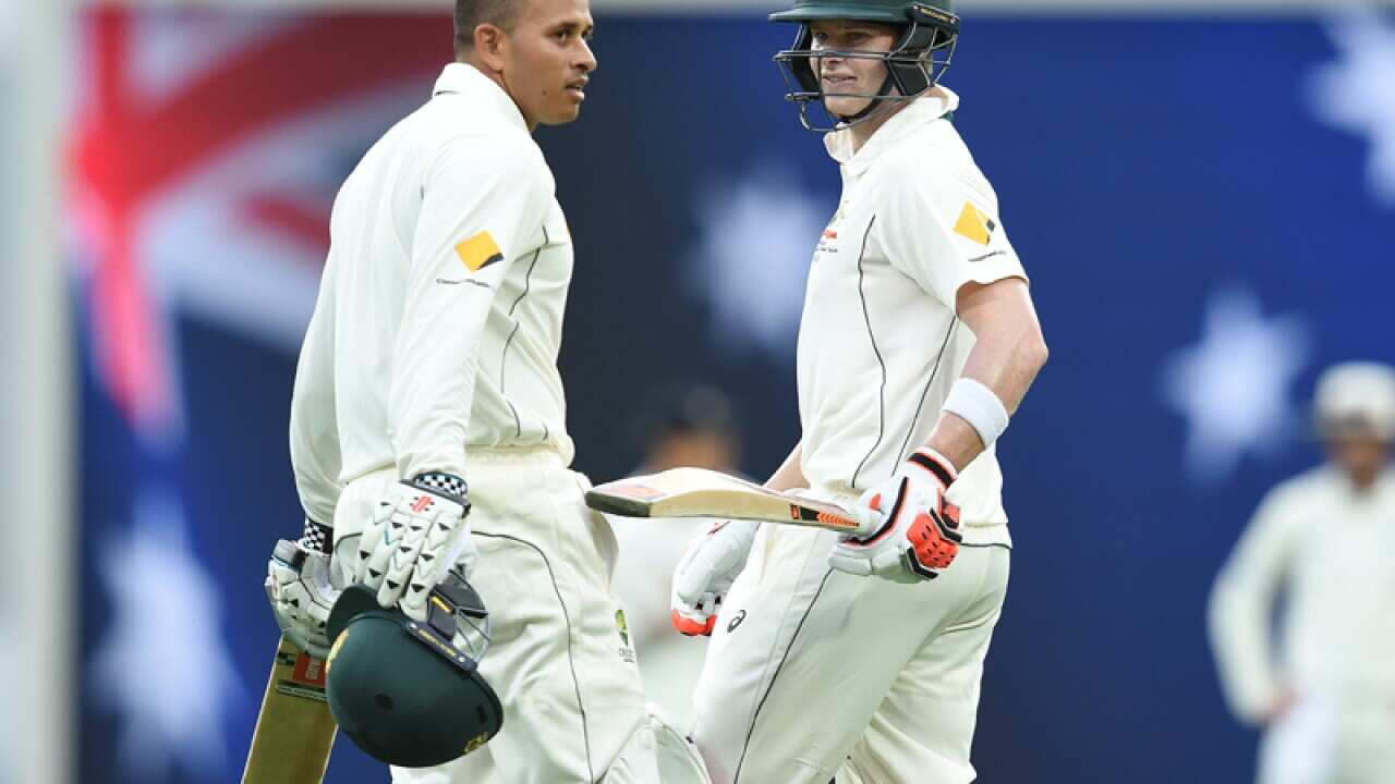 Australian batsman Usman Khawaja (L) reacts with captain Steve Smith
