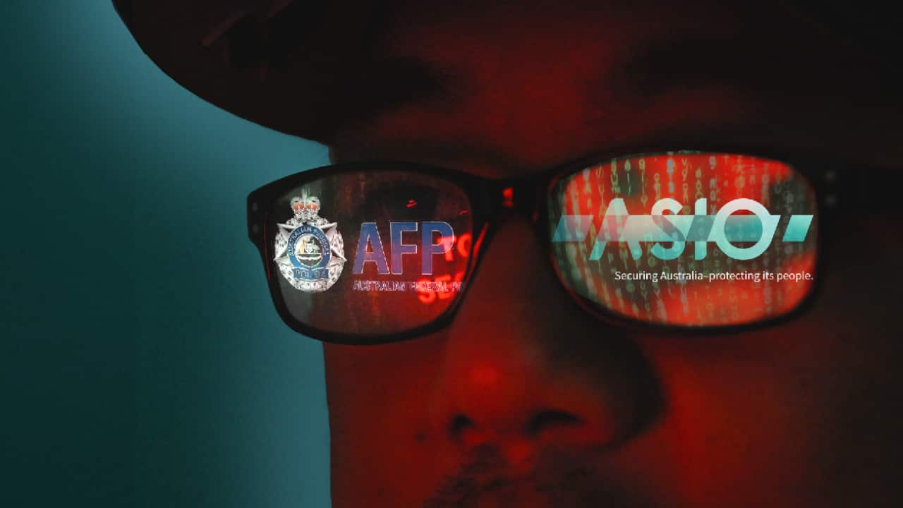 A portion of a man's face, with glasses visible. In their reflection, AFP and ASIO logos.