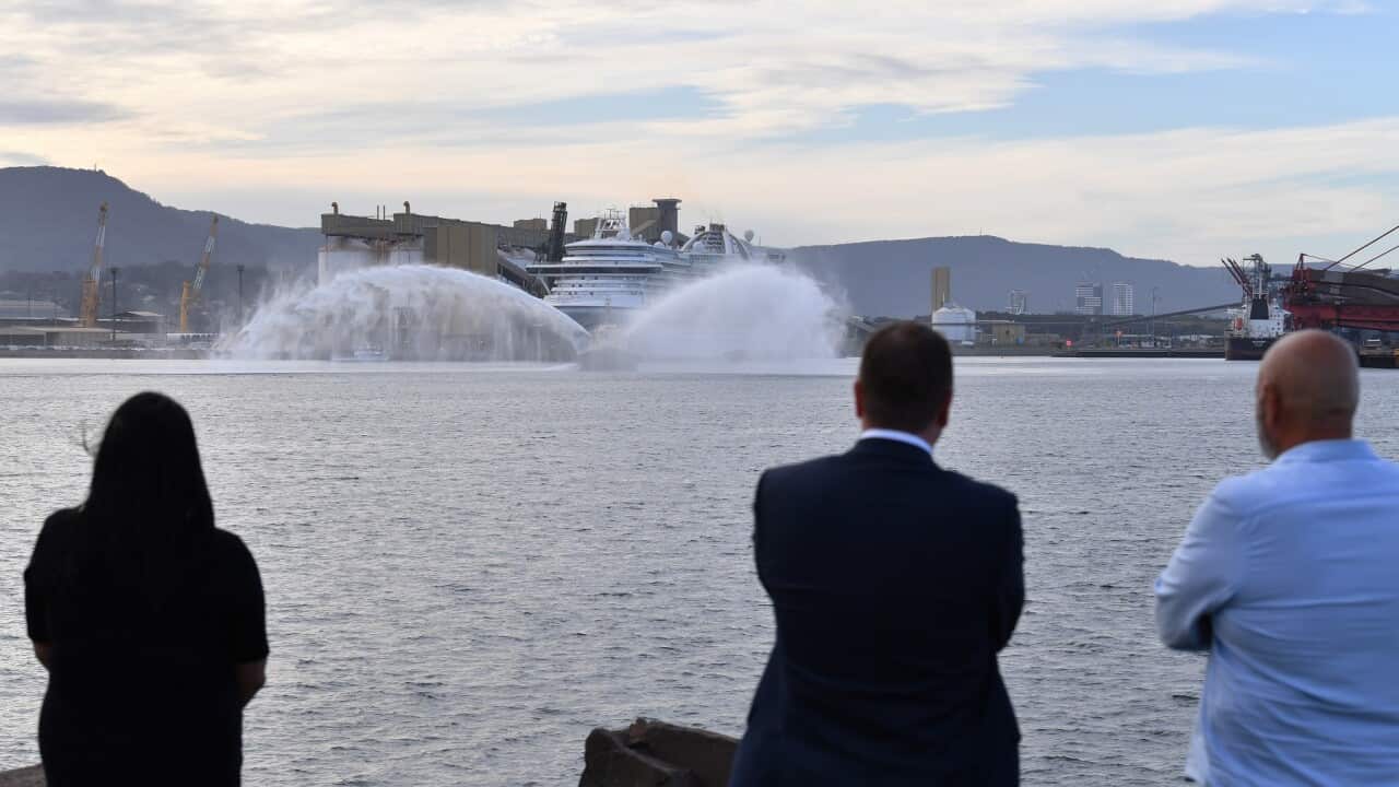 A tug sprays water as the Ruby Princess prepares to depart Port Kembla