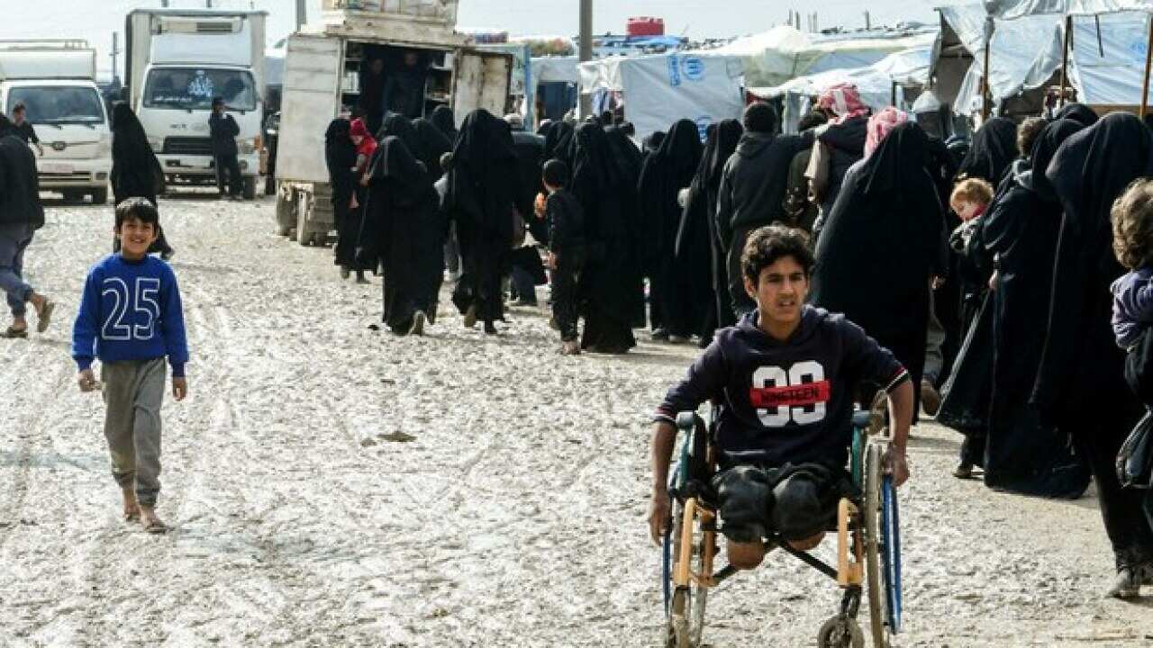 Veiled women, who live in the al-Hol camp that houses relatives of Islamic State militants, queue up to receive goods in north eastern Syria.