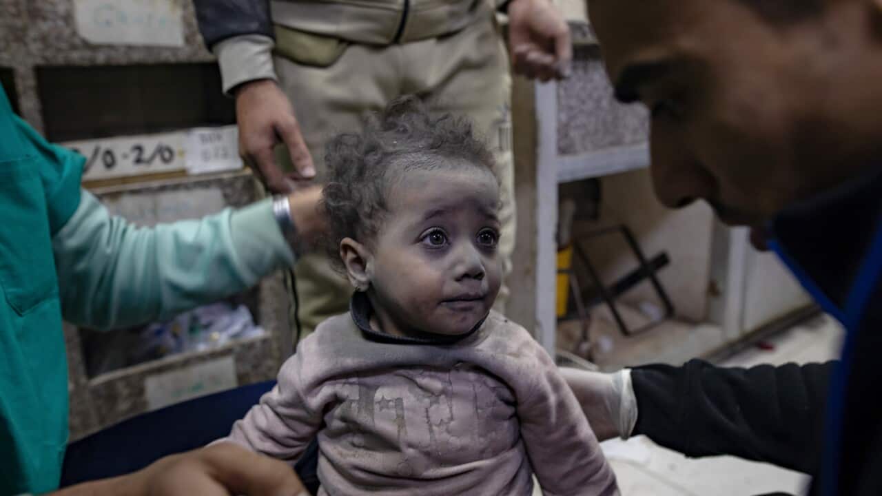 A child covered by soot looks at a man